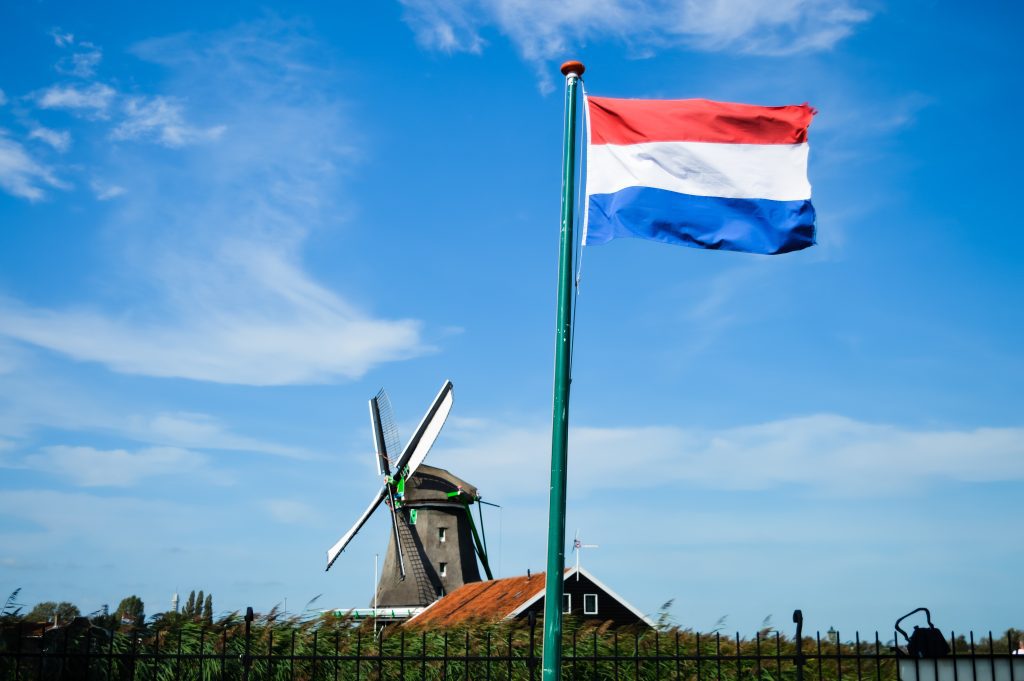 flaga holandii na maszcie na tle niebieskiego nieba - Progi podatkowe w Holandii, a w Polsce